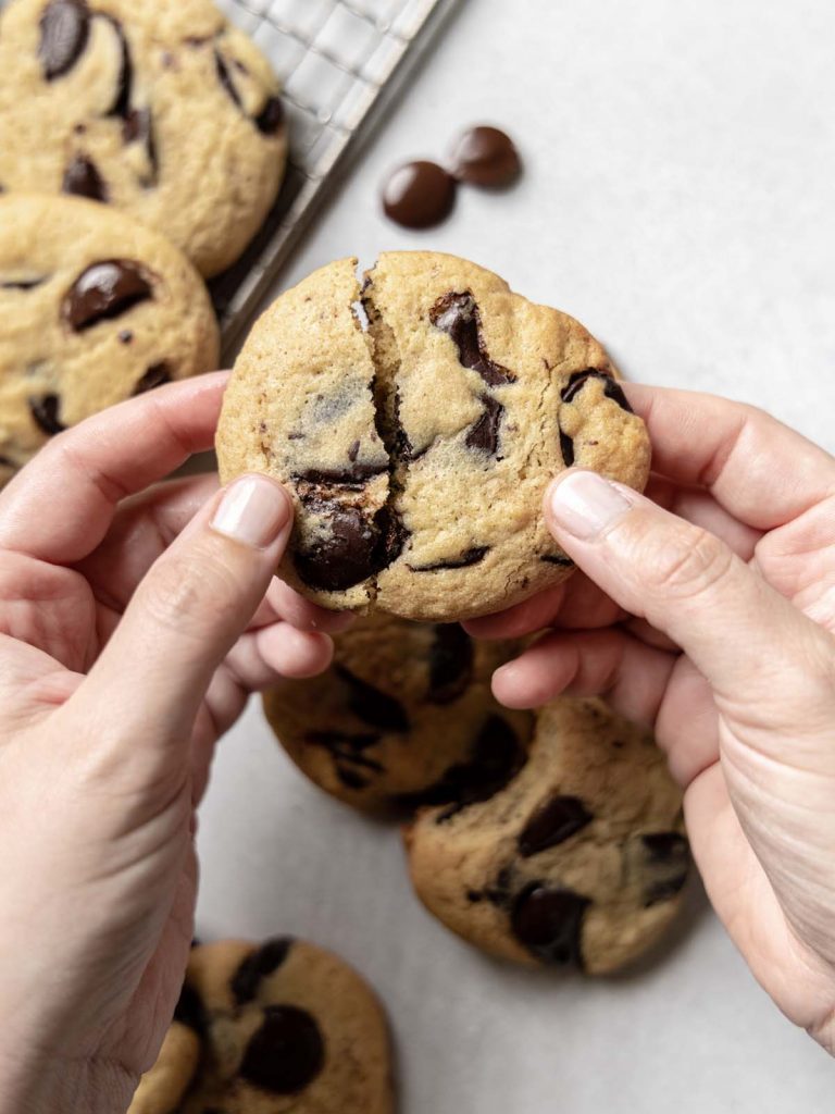 Breaking open cookie above cooling rack.