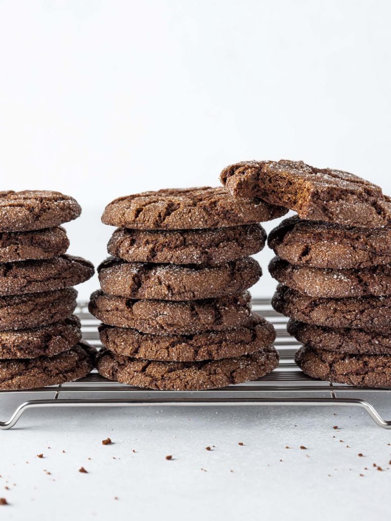 Stacked sugared molasses cookies with bite removed from top cookie.