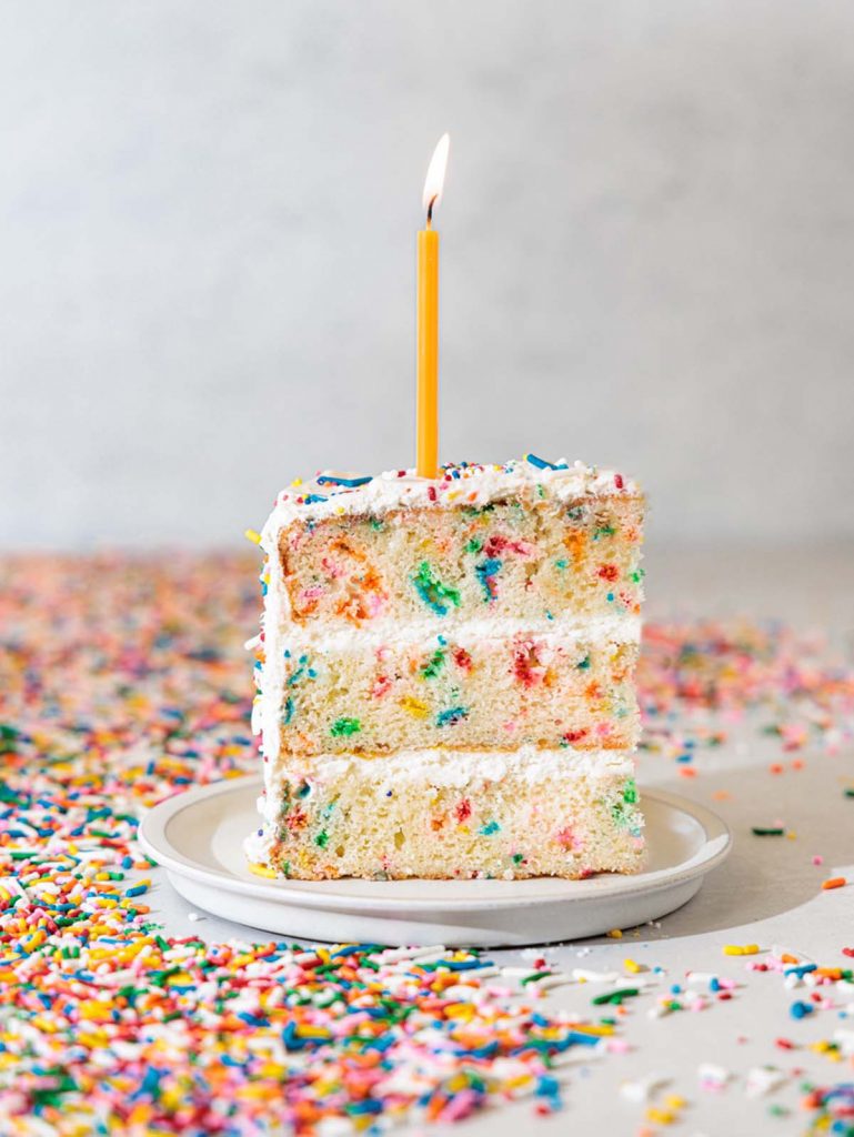 Homemade Confetti Cake slice straight on with candle