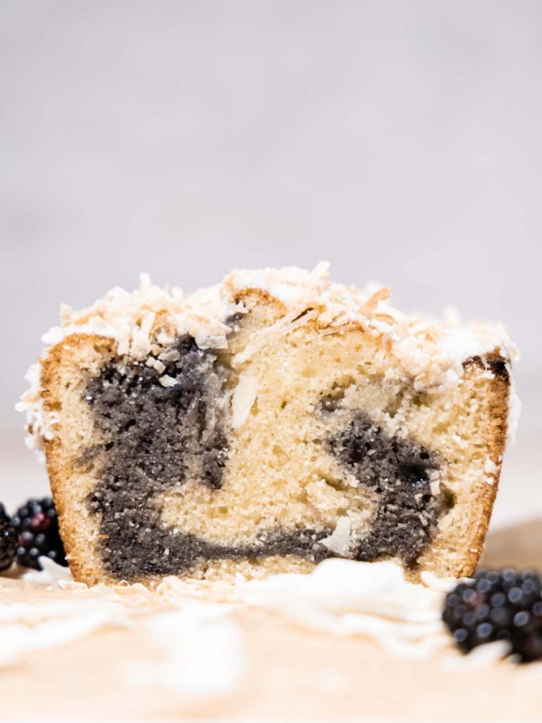 Slice of loaf cake with blackberry swirl in the center.