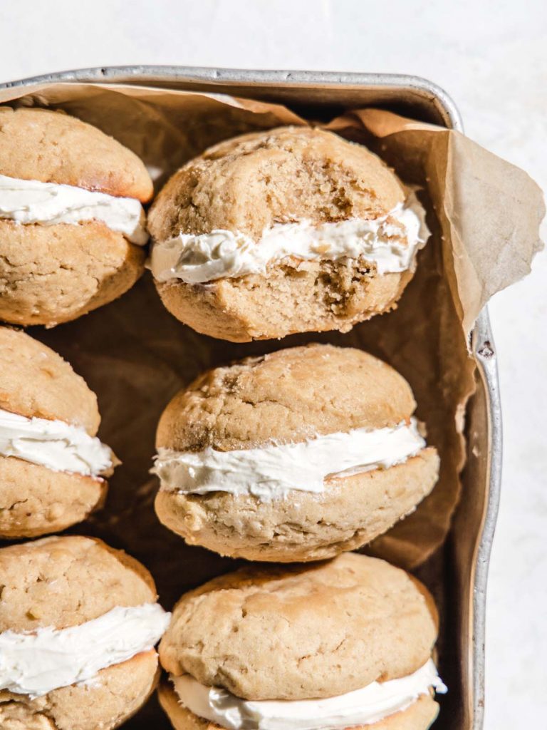 Whoopie pies with marshmallow filling in tin with bite removed.