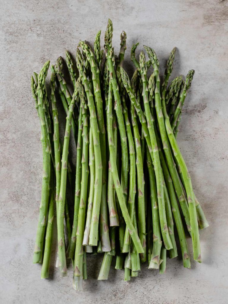 Bunch of asparagus of board.