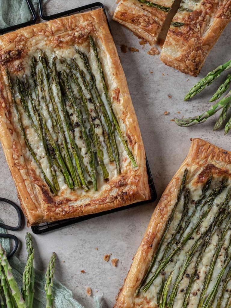 Asparagus Tarts on cooling racks with slices and raw asparagus on the side.