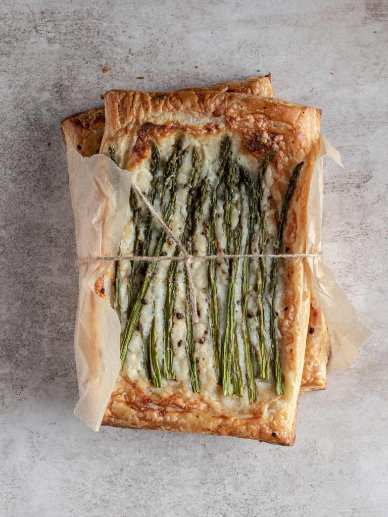 Asparagus Tarts wrapped with twine and paper on board.