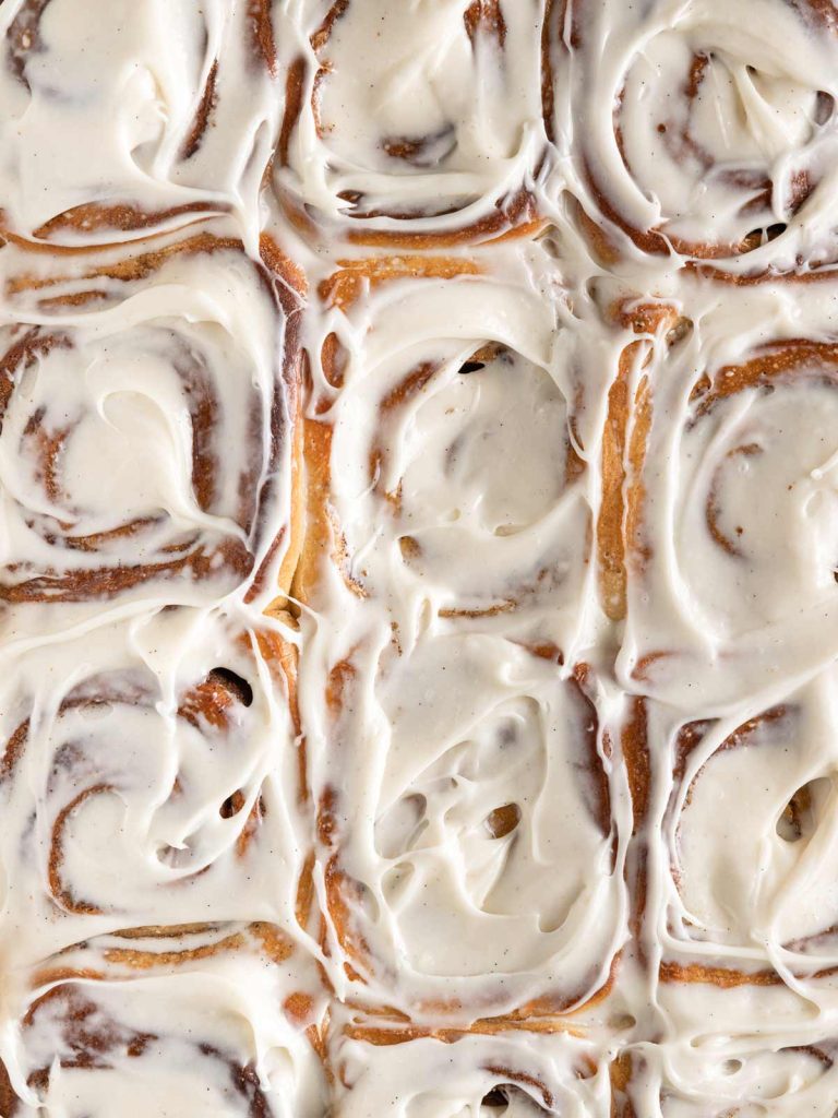 Overhead close up of frosted cinnamon rolls.