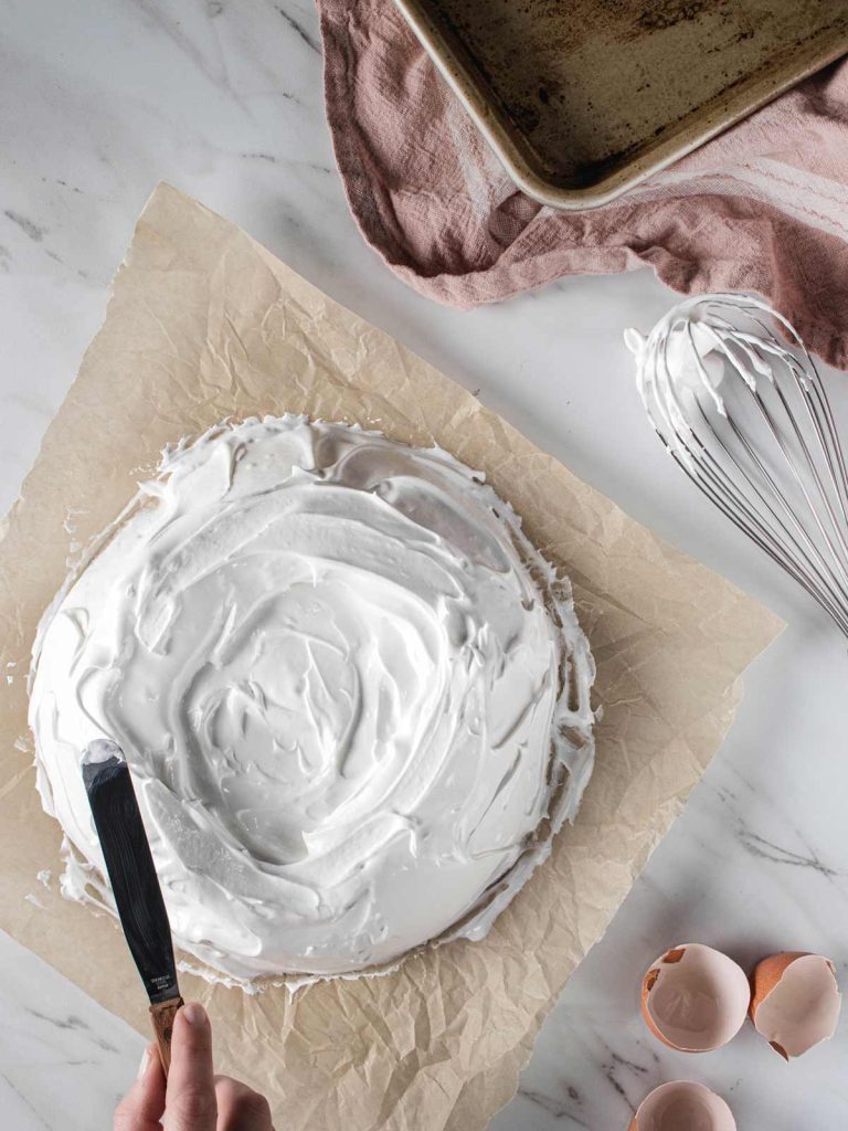 Making pavlova shapes with spatula and meringue covered whisk.