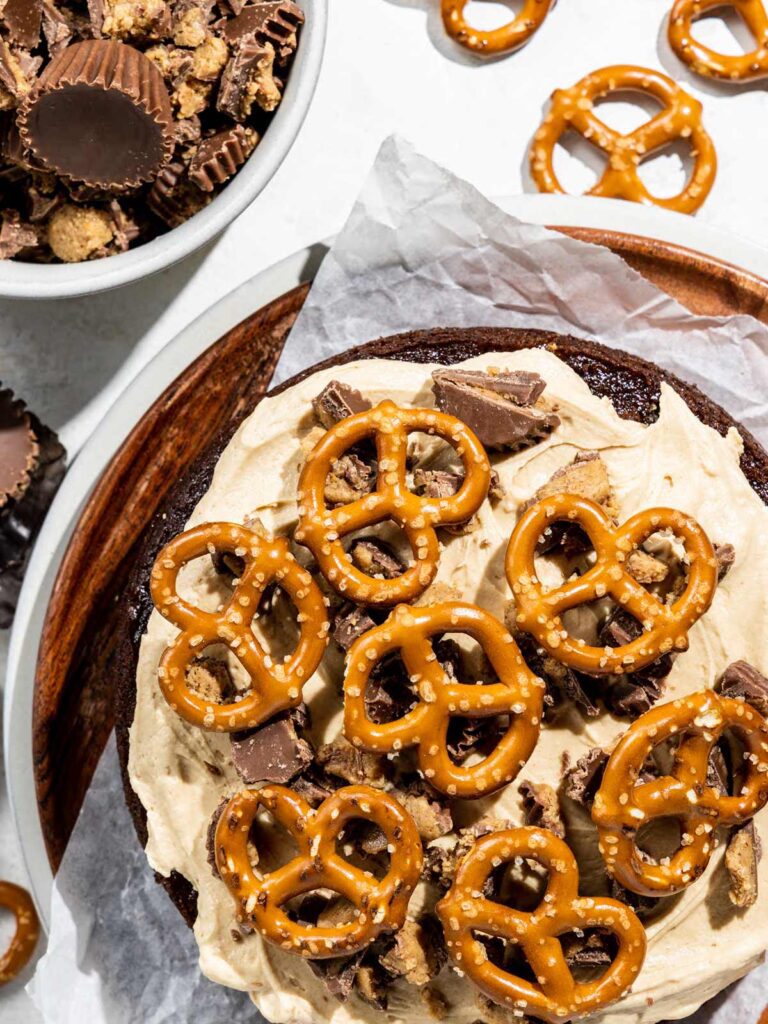 Close up of chocolate cake layer with Reese's and pretzels on top.