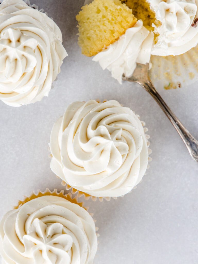 Three cupcakes from the top and one cupcake with a piece on a fork.