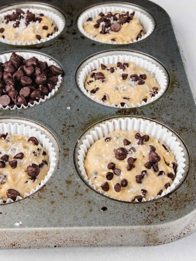 Side view of muffin batter in tin with chocolate chips.