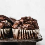 Side view of chocolate muffins in baking tin.