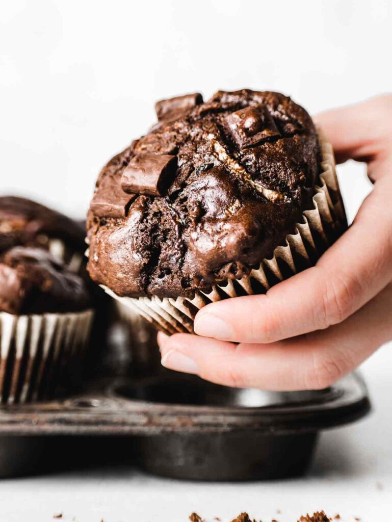 Holding up muffin with chocolate chunks.