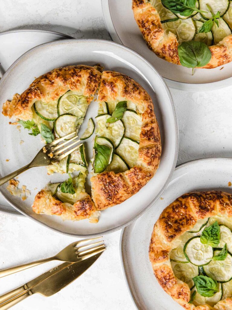 Three galettes on plates with one cut with a fork.