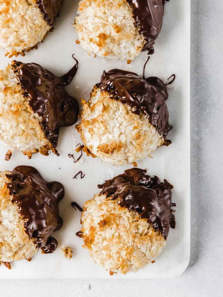 6 macaroons on marble board with chocolate dip.