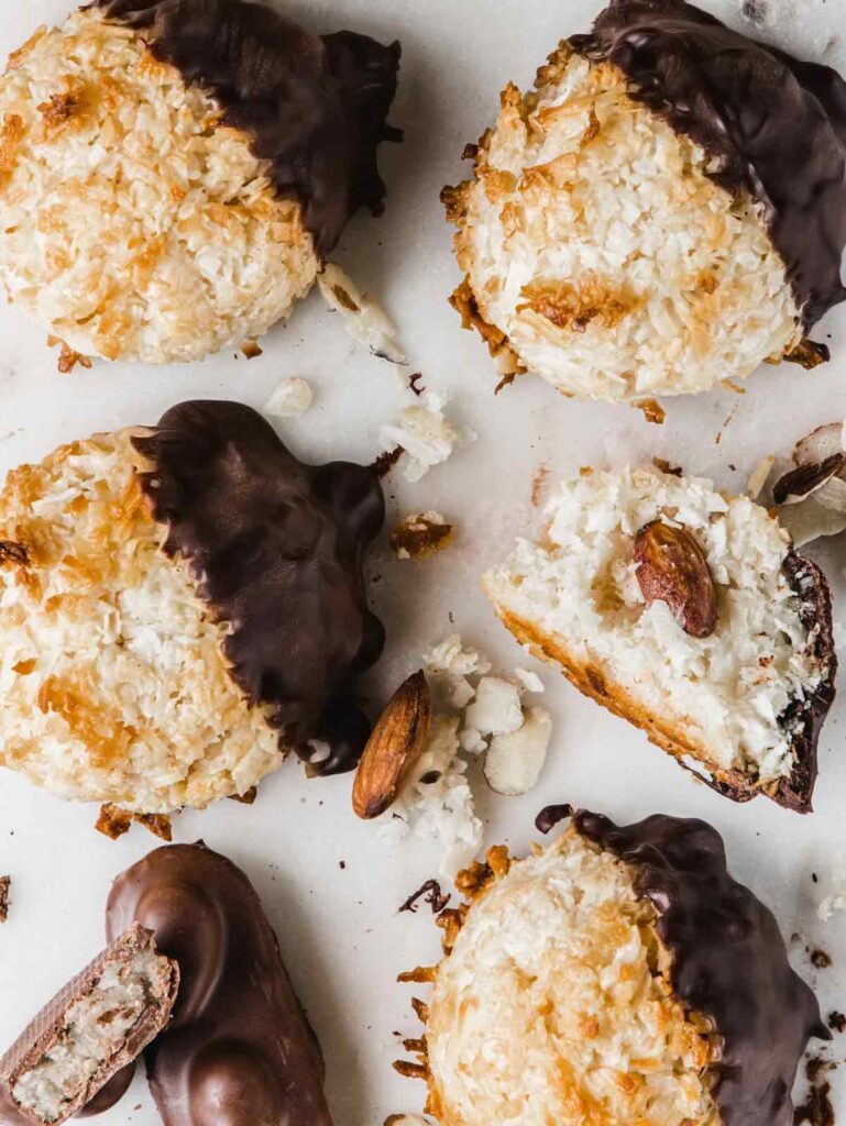 Macaroons on board with one broken open and Almond Joy candy.