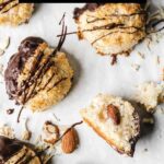 Macaroons on parchment paper with chocolate drizzle.