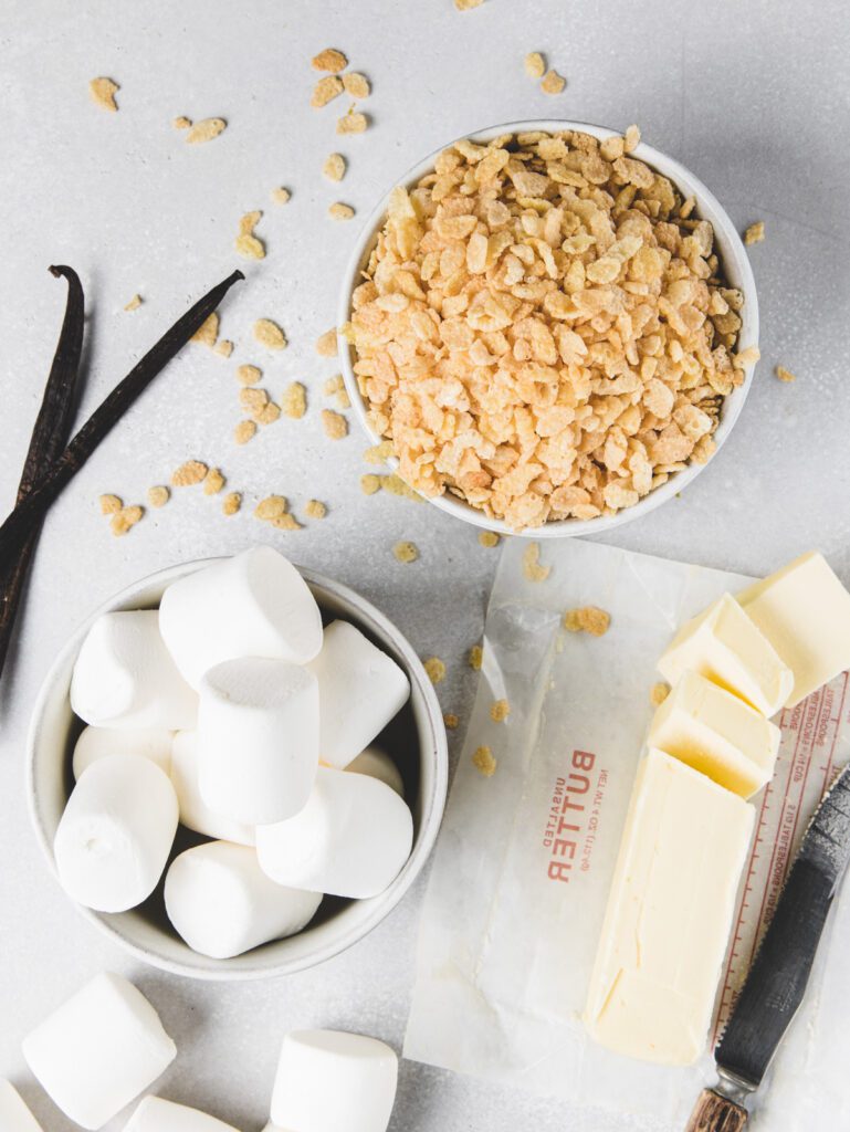 Rice crispy treat ingredients in bowls on table.