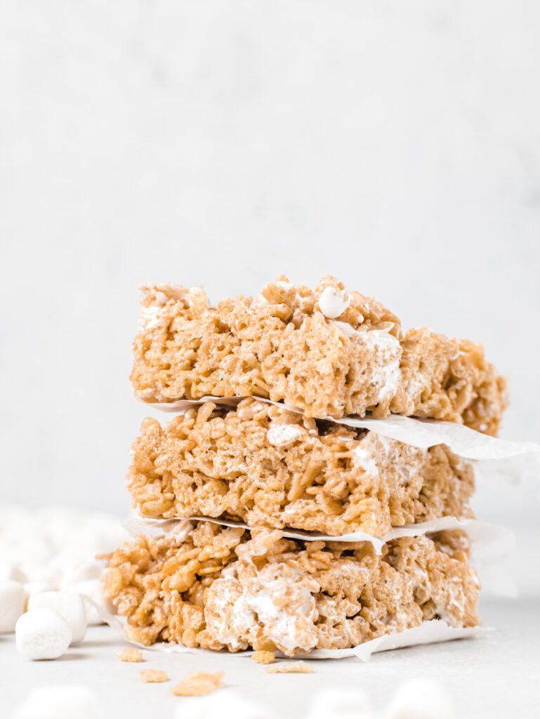 Stack of cereal treats with parchment between.