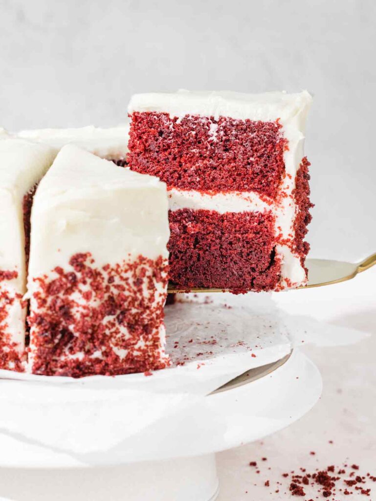 Removing slice of red velvet cake from cake stand.