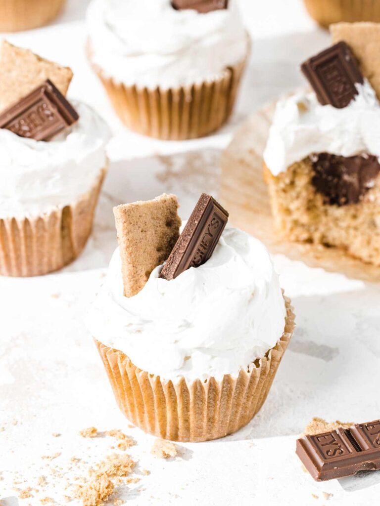 S'mores cupcakes with graham crackers and chocolate squares on top.