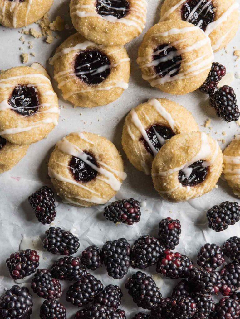 Pile of blackberries with thumbprint cookies.