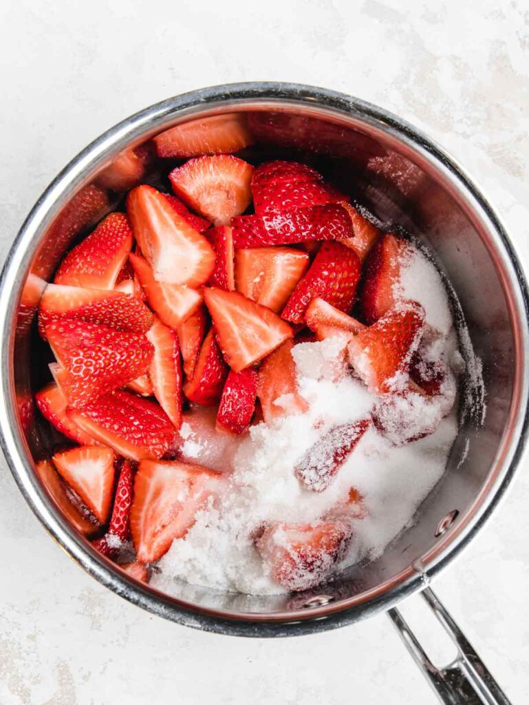 Sliced strawberries in saucepan.