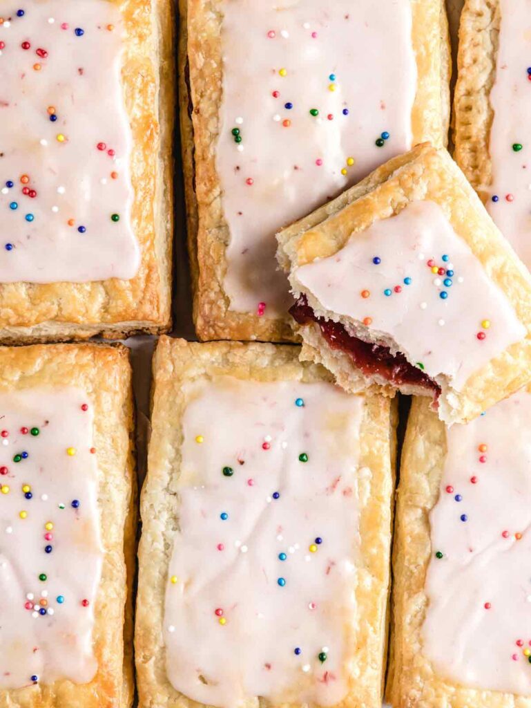 Close up of 6 pop tarts with one broken on top.