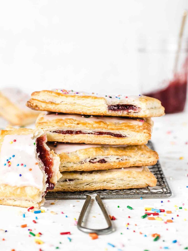 Stack of 4 pop tarts with jam jar in background.