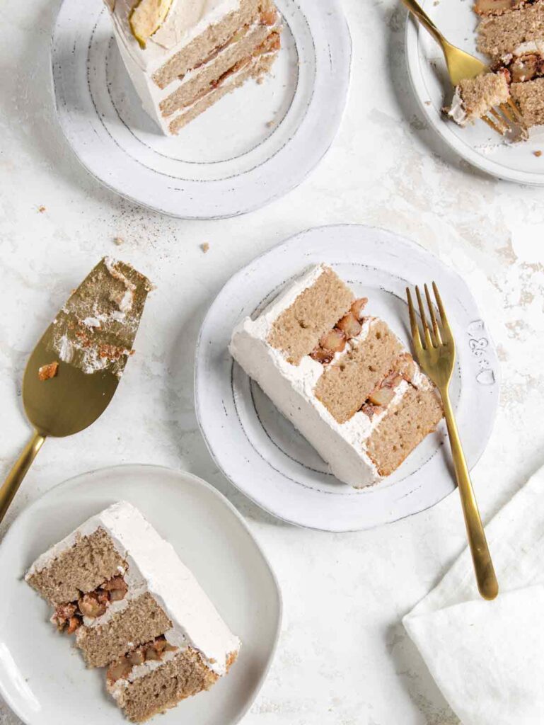 4 plates with slices of cake with apple filling.