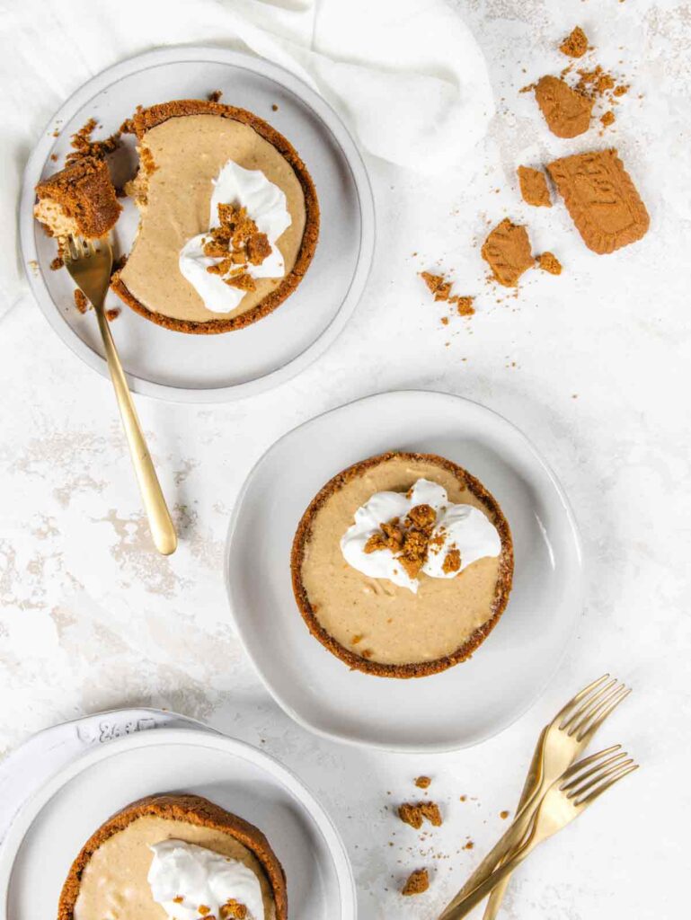 Three pumpkin cheesecakes on plates with forks.