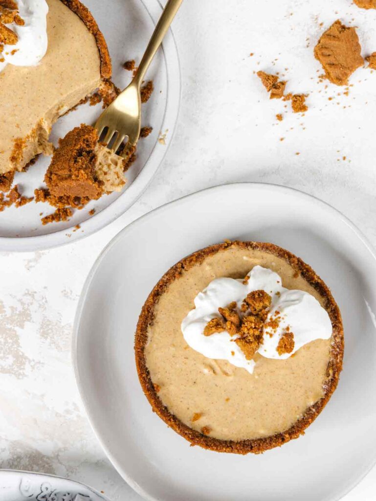 Two pumpkin cheesecakes on plates with forks.