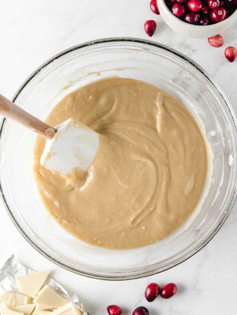 Loaf bread batter in bowl with spatula.