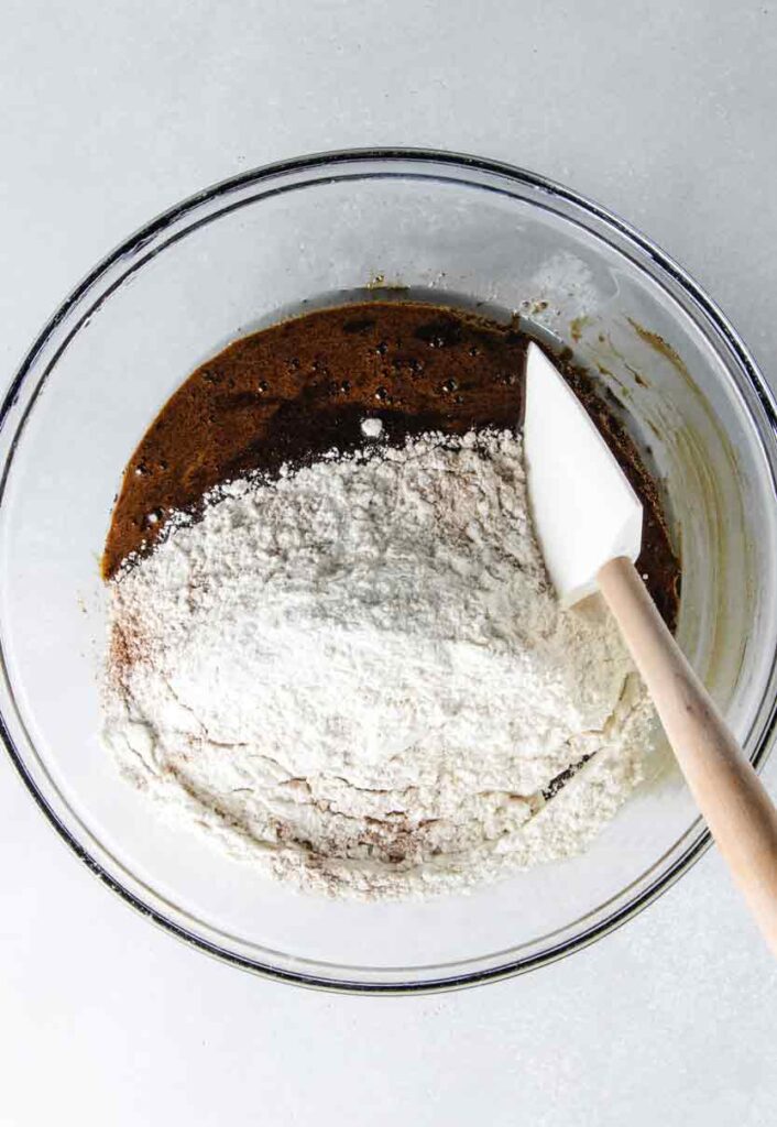 Flour being added to bowl with spatula.