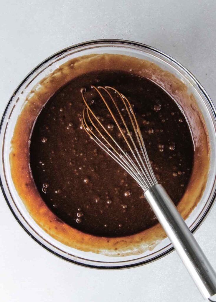 Cake batter in bowl with whisk.