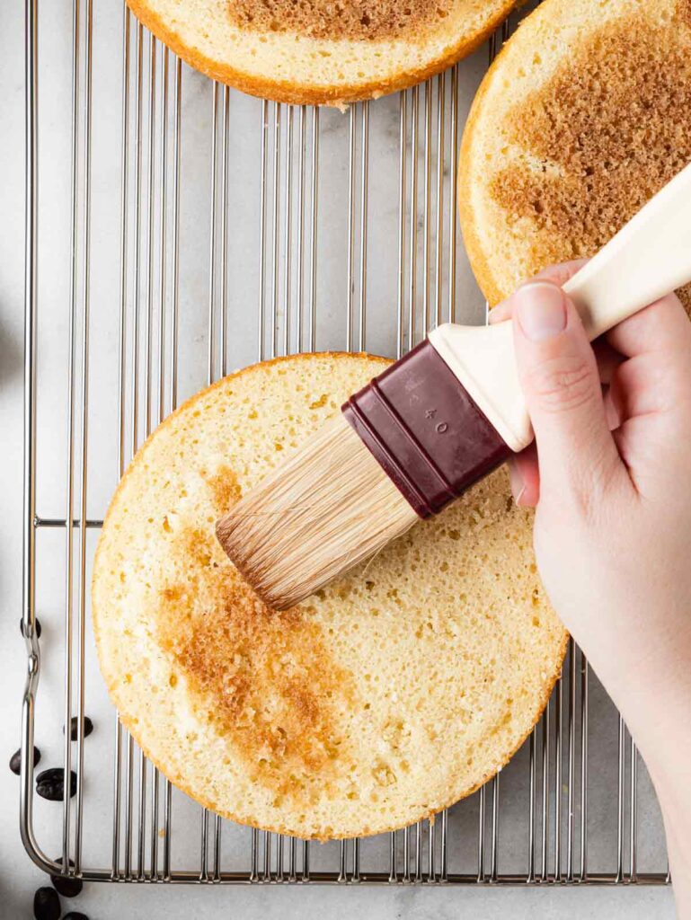 Brushing coffee soak on cake layer.