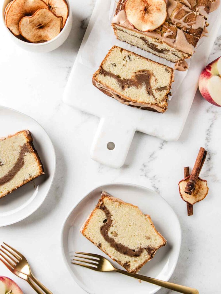 Slices of apple pound cake on 2 plates and with serving board.