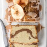 Sliced pound cake on board with dried apples.