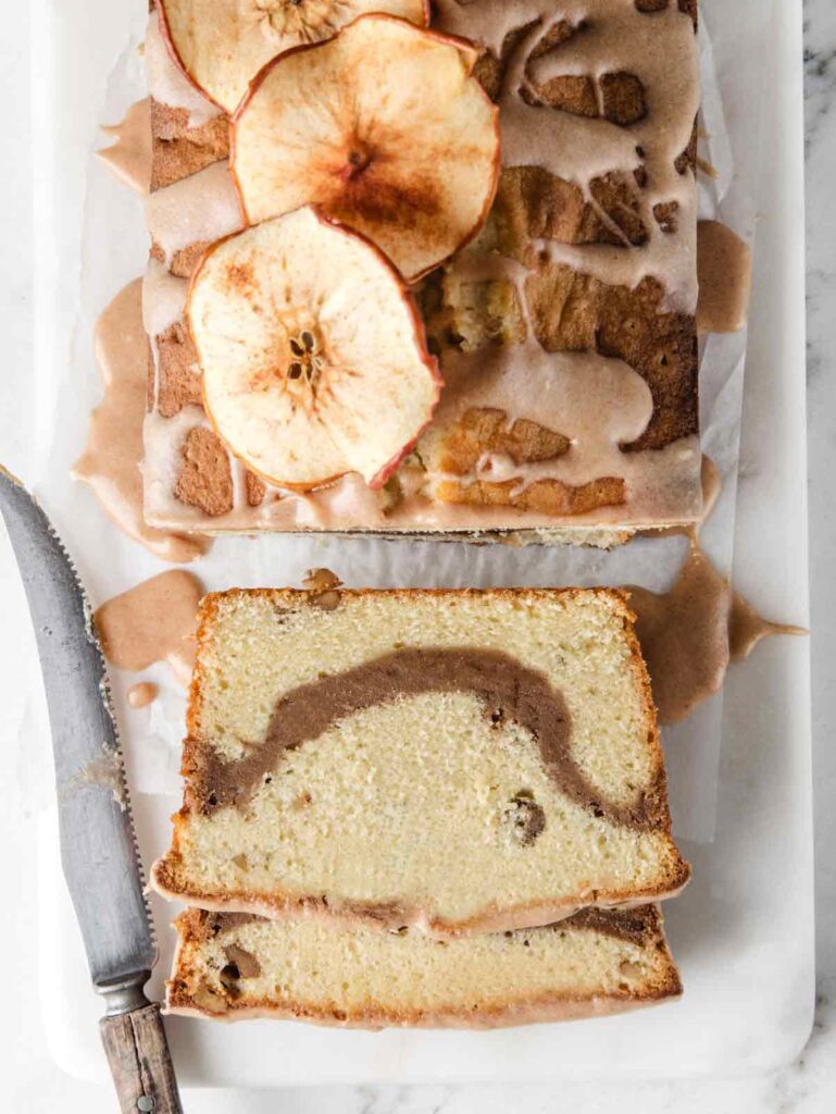 Sliced pound cake on board with dried apples.