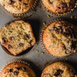 Chocolate and orange muffins in tin with one cut open.