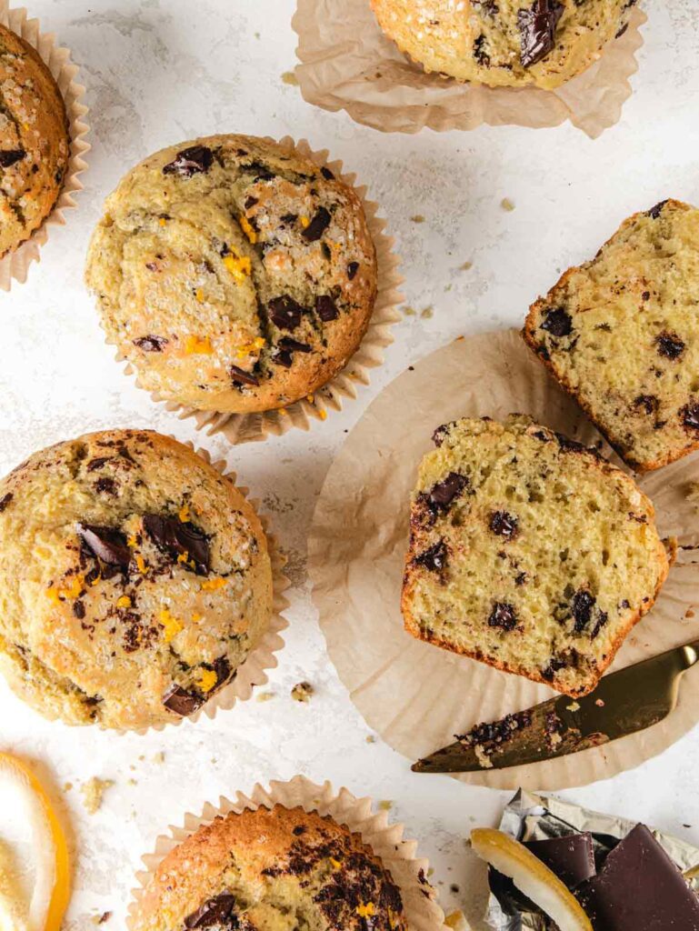 Chocolate muffins on board with one sliced in half with knife.