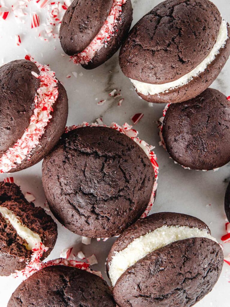 Pile of chocolate whoopie pies on board with crushed candy canes.
