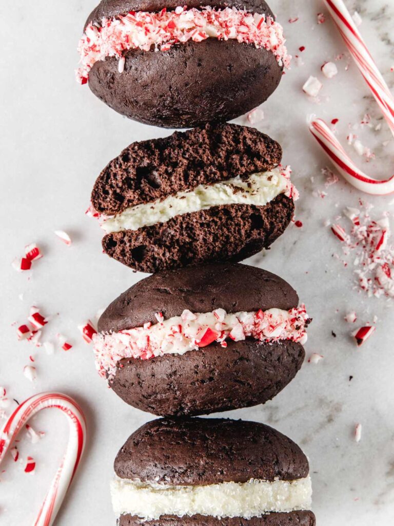 Line of chocolate peppermint whoopie pies with one broken in half.