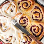 Cranberry rolls being iced.