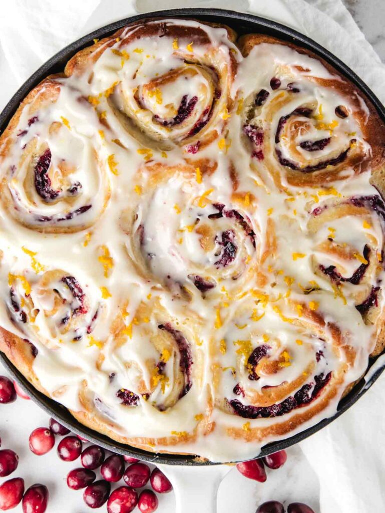 Iced orange rolls in pan.