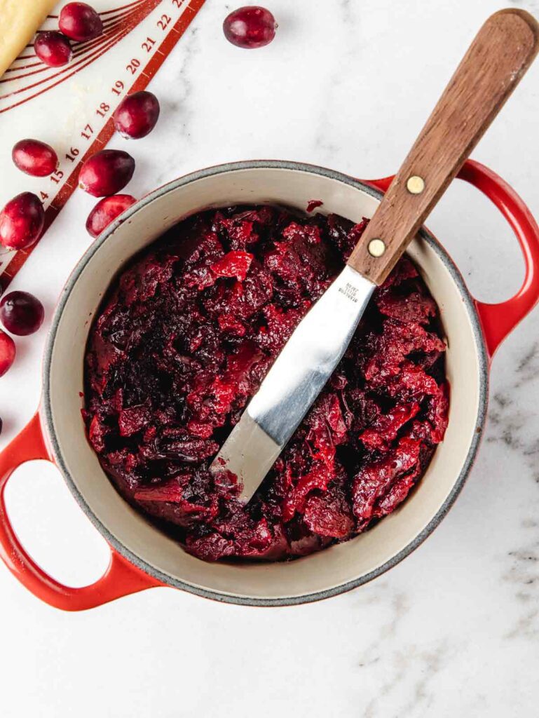 Cranberry jam in pot with spatula.