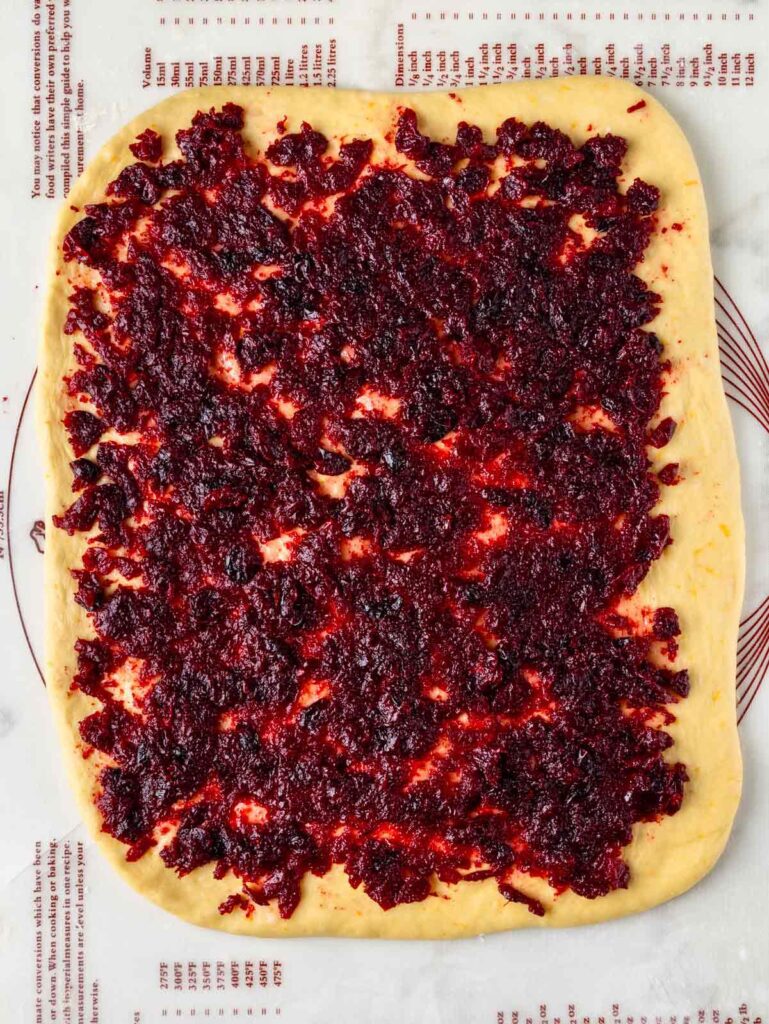 Dough with cranberry jam spread over.