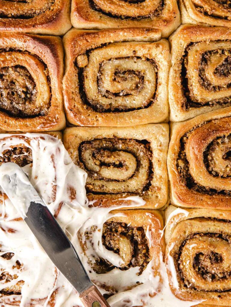 Unfrosted swirled rolls with knife spreading icing.