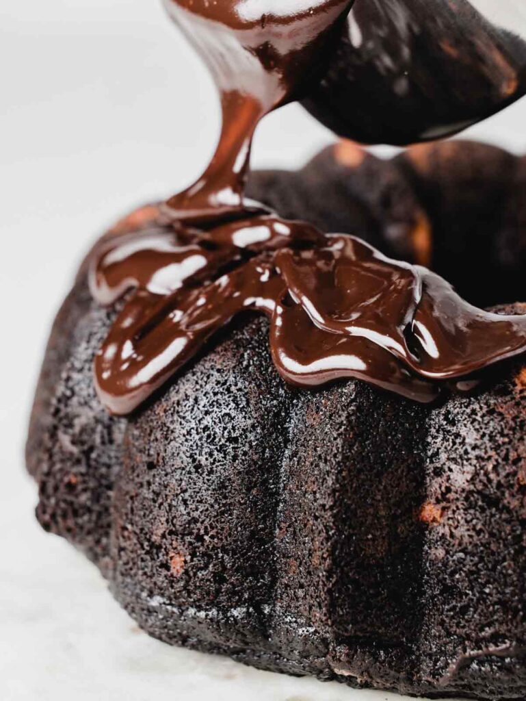 Pouring chocolate glaze on bundt cake.