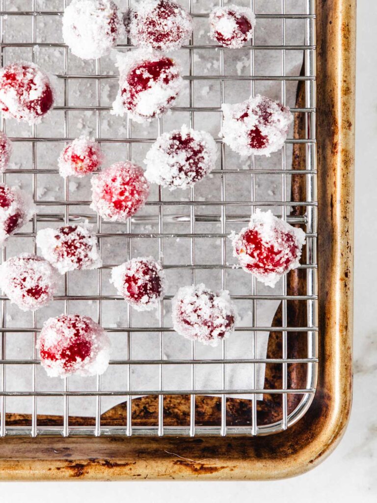 Sugared cranberries on sheet pan with cooling rack.