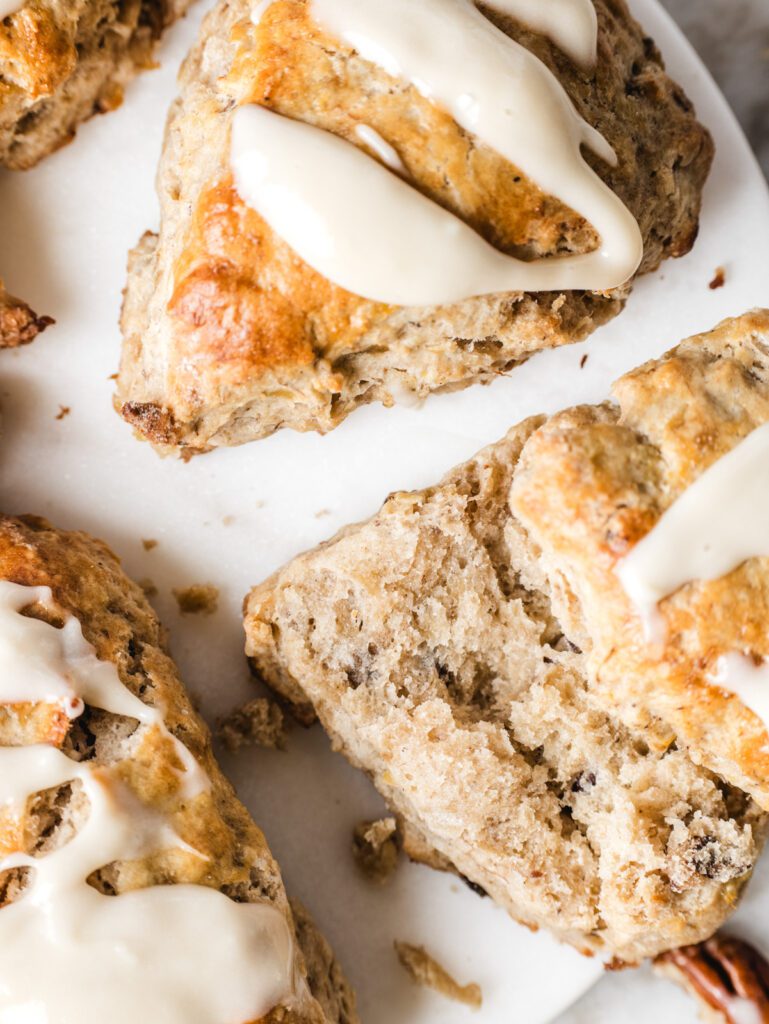 Close up of scones with glaze on top with one sliced in half.