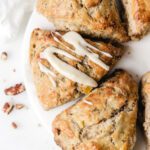 Scones on a circle marble board with glaze on one.